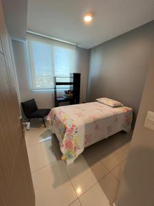 圣何塞Bambu-Rivera Club Residences的卧室配有床、椅子和窗户。