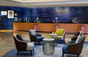 新加坡voco Orchard Singapore, an IHG Hotel的一个带椅子和柜台的等候室