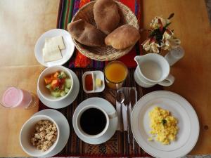 奥兰太坦波Ayllu B&B Ollantaytambo的餐桌,盘子上放着食物,咖啡和面包