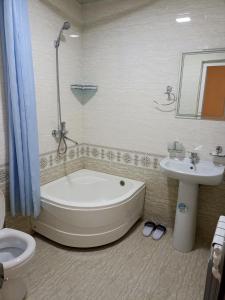 撒马尔罕OQSAROY SAMARKAND Guest House的带浴缸、盥洗盆和卫生间的浴室