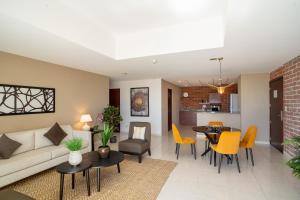 危地马拉Adriatika Hotel & Residence的客厅配有沙发和桌子