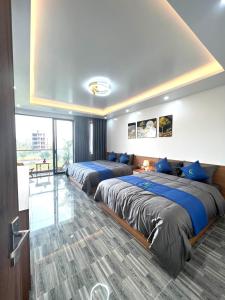 岑山An Cường Hotel的两张位于酒店客房的床,配有蓝色枕头