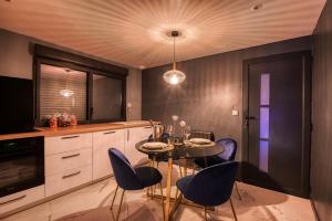 圣西尔-莱科勒Villa avec jacuzzi privatif的厨房配有紫色椅子和桌子