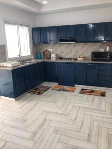 Ḩammām al GhazzāzFamily house的厨房配有蓝色橱柜和白色瓷砖地板。