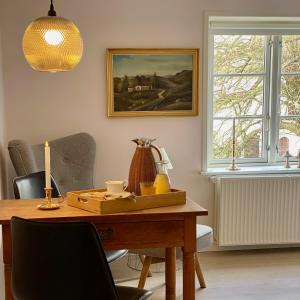 森讷堡Rønhave的一间用餐室,配有一张桌子和一张墙上的照片