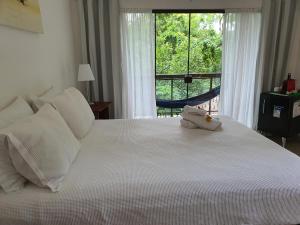 阿布拉奥Ohana suíte Abraão - Ilha Grande的卧室配有一张大白色床和窗户