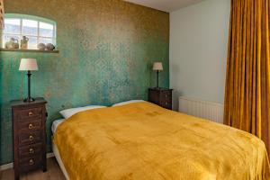 GasselteB&B De Buren的一间卧室配有一张带黄色毯子的大床