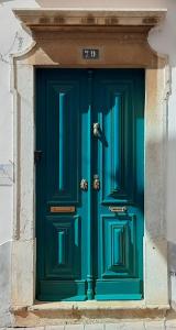 法鲁A Casa do Tenente的建筑物上带号码的绿色门
