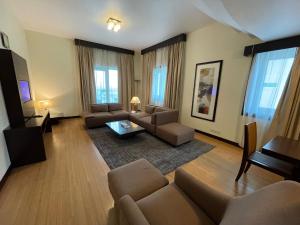 迪拜Tulip Creek酒店式公寓的客厅配有沙发和桌子