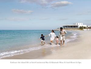 拉斯阿尔卡麦InterContinental Ras Al Khaimah Resort and Spa, an IHG Hotel的一家在海滩上散步
