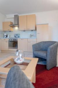 提努姆Haus Lia Rechts App 5的一间带桌椅的客厅和一间厨房