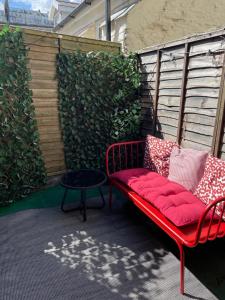 伊尔弗勒科姆The Antidote的庭院里的一个红色长凳和一张桌子