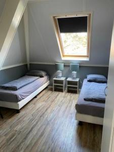 霍勒姆Appartement Zilt的一间卧室设有两张床和窗户。