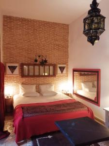 非斯Les Bains de Fez Tara的一间卧室设有一张大床和砖墙