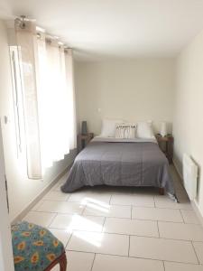 圣马迪拉莫Appartement le loft的卧室配有床,铺有白色瓷砖地板。