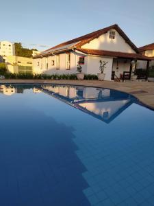 兰巴里Pousada do Duque的一座大蓝色游泳池,位于房子前