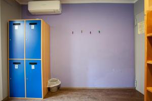 皮兰亚得里亚海皮兰旅馆的一间设有两个蓝色储物柜和一面墙壁的房间