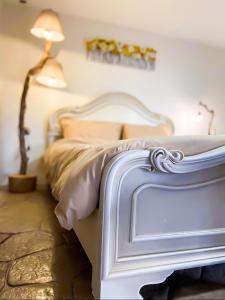VathíPistachio Guesthouse, Παραδοσιακός ξενώνας的卧室配有白色的床和灯