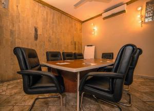 达累斯萨拉姆斗兽场精品酒店&Spa的一间会议室,配有桌子和黑椅子