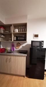 MarilaoRelaxing 1-Bedroom Condo Unit (by Lee Portum)的厨房配有水槽和黑冰箱。