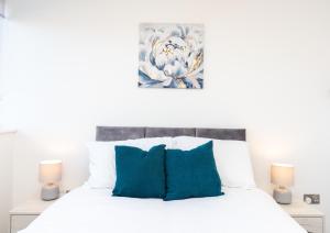 金斯林Modern Apartments in Kings Lynn with Free Wi-Fi的一间卧室配有白色床和蓝色枕头