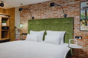 卢布尔雅那ONE66 Hotel的卧室配有白色的砖墙床