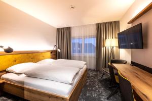 EggenburgSleep in Premium Hotel Eggenburg的配有一张床和一张书桌的酒店客房