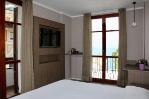 法杰托拉廖瓦波雷餐厅酒店的一间卧室设有一张床、一台电视和一个阳台。