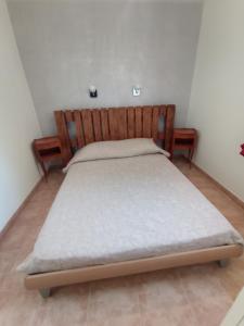 帕特里莫尼奥villa bana的一间卧室配有一张带木制床头板的床