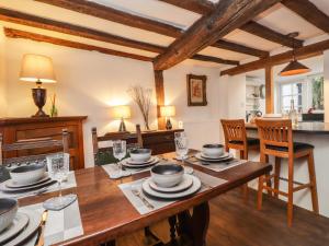 桑德维奇Tudor Cottage的厨房以及带木桌的用餐室。
