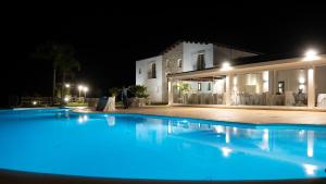 卡拉塔菲米La Corte del Sole的夜间在房子前面的游泳池