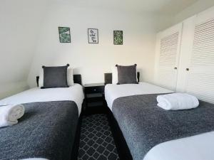 布里斯托Cheerful 5-bedroom with free parking的白色墙壁客房中的两张单人床