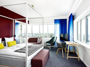 奥胡斯Comwell Aarhus Dolce by Wyndham的配有一张床和一张书桌的酒店客房