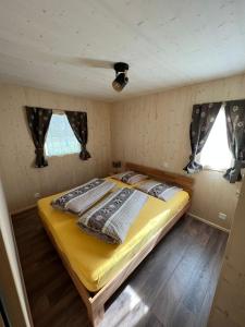 波斯基亚沃Bungalow Miralago in Camping Cavresc, Via dal Cavresc 1, 7746 Le Prese-Poschiavo的一间小房子里的卧室
