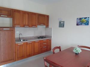 苏莎亚CoralK Apartments Sosúa的厨房配有木制橱柜和木桌。