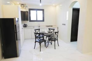 塔伊夫Al Khuzama Resort的厨房配有桌椅和冰箱。