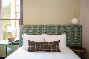 旧金山EPIK酒店的一间卧室配有一张带绿色和白色床头板的床