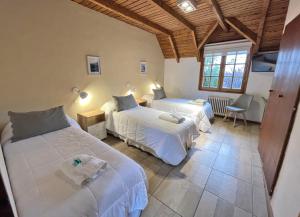 圣马丁德洛斯Latitud Cuarenta的酒店客房设有两张床和窗户。