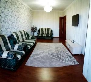 奇姆肯特Центр Чимкент Двушка的客厅配有两张沙发和地毯。