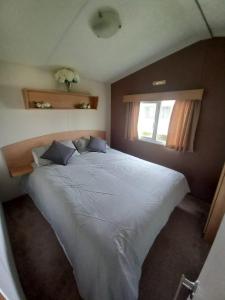 Saint OsythJacqueline's holiday homes seawick clacton on sea的卧室内的一张大白色床,带有窗户