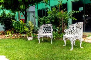 库亚巴德尔卡斯酒店的两把白色椅子坐在院子里的草地上