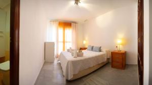 加的斯Brasil Playa Ha Apartment的白色的卧室设有床和窗户