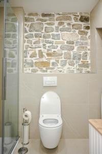皮兰BAY BREEZE Holiday house in Piran的浴室配有白色卫生间和石墙。