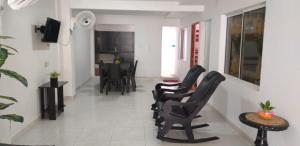 托卢Hostal Girasoles Tolu的客厅配有黑色椅子和桌子