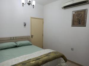 沙迦Furnished Apartment的一间白色客房内的床铺卧室