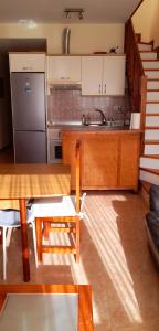 科拉雷侯The Summer Treat Shared Apartment Compartido的厨房配有木桌和冰箱。