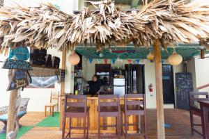 圣佩德罗Lina Point Belize Overwater Resort的餐厅设有1间带稻草伞的酒吧