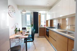 克卢日-纳波卡Gold Class Apartments AMS的厨房配有桌椅和墙上的时钟