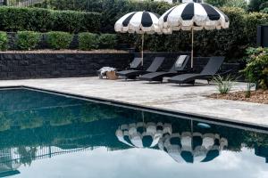 马莱尼墨兰莉小屋酒店的一个带躺椅和遮阳伞的游泳池