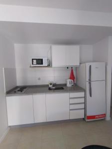 罗萨里奥kira的厨房配有白色橱柜和白色冰箱。
